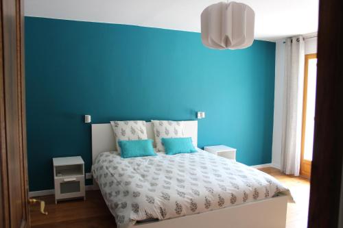 a bedroom with a blue wall and a bed at LE LIT QUI DANSE in Mollans-sur-Ouvèze