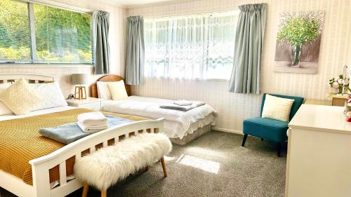a bedroom with a bed and a couch and a chair at Rotorua City Center Holiday House in Rotorua