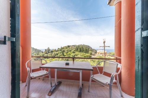 a table and chairs on a balcony with a view at Arianna apartment 10 in Paleokastritsa