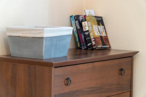 a box on top of a wooden dresser with books at Arianna Studio 16 in Paleokastritsa