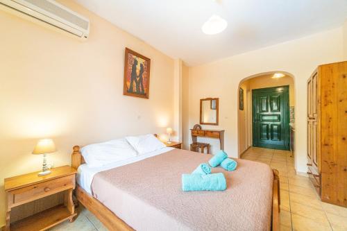 a bedroom with a bed with a blue stuffed animal on it at Arianna Studio 16 in Paleokastritsa