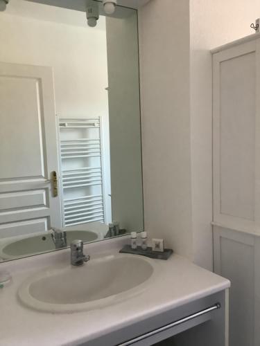 łazienka z umywalką i dużym lustrem w obiekcie Les Oliviers w mieście Mallemort