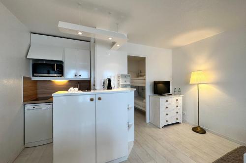 a kitchen with white cabinets and a white refrigerator at Les Tamaris - Studio with Sea View - Trouville-Sur-Mer in Trouville-sur-Mer