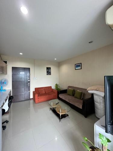 The Ozone Krabi Condotel في مينْغكرابي: غرفة معيشة مع أريكة وطاولة