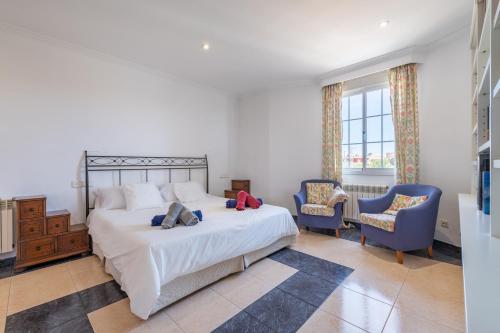 sypialnia z łóżkiem i 2 niebieskimi krzesłami w obiekcie Villa Laura w Palma de Mallorca