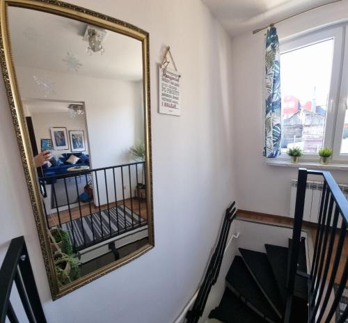 un espejo en una pared junto a una escalera en Apartamenty Tomaszów Lubelski - Niebieski, en Tomaszów Lubelski