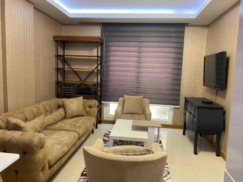 a living room with a couch and a television at Antalya liman Apartment 1+1 in Antalya