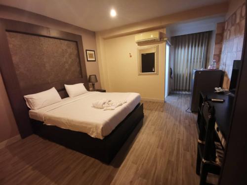 Habitación de hotel con cama y TV en Metro Residence en Surin