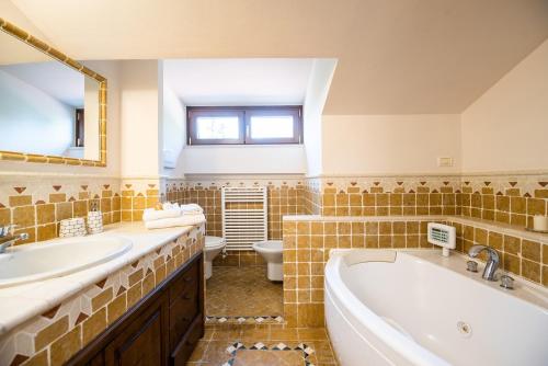 ein Badezimmer mit einer Badewanne, einem Waschbecken und einem WC in der Unterkunft La Ginestra in Fiore Camere in Sirolo