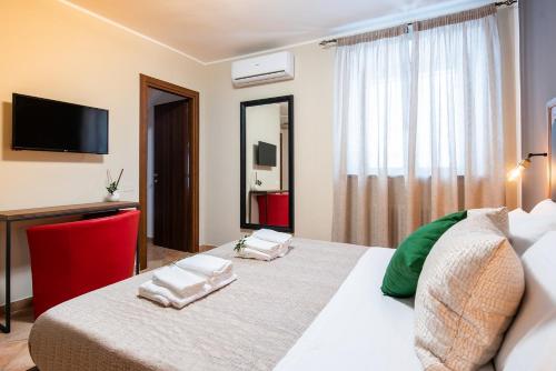 ein Schlafzimmer mit einem großen Bett und einem TV an der Wand in der Unterkunft La Ginestra in Fiore Camere in Sirolo