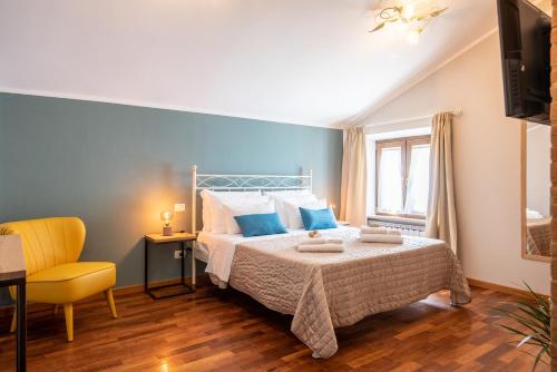 a bedroom with a bed with blue walls and a yellow chair at La Ginestra in Fiore Camere in Sirolo