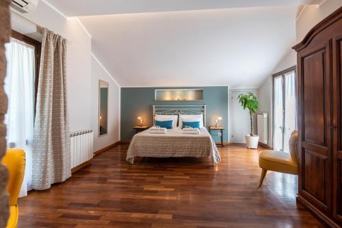 a bedroom with a bed with blue walls and wooden floors at La Ginestra in Fiore Camere in Sirolo