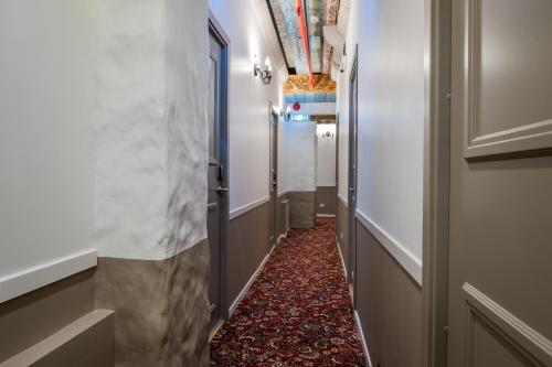 a hallway with a marble wall and a red carpet at Three Crowns Residents in Tallinn