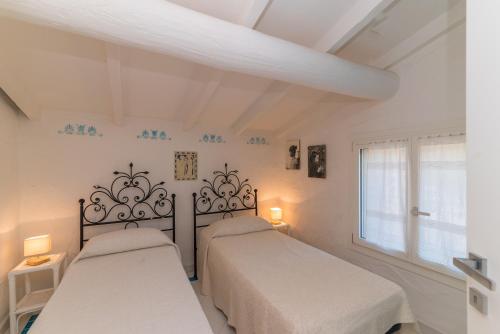 コスタ・コラッリナにあるVilla Corallinaの白い部屋 ベッド2台 窓付