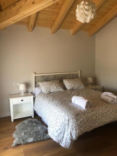 a bedroom with a bed and a wooden ceiling at La Bodega de Antonio in Faramontanos de Tábara