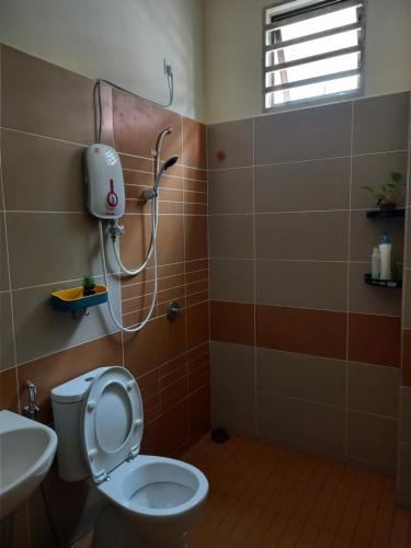 uma casa de banho com um WC e um chuveiro em RS Homestay em Sungai Petani
