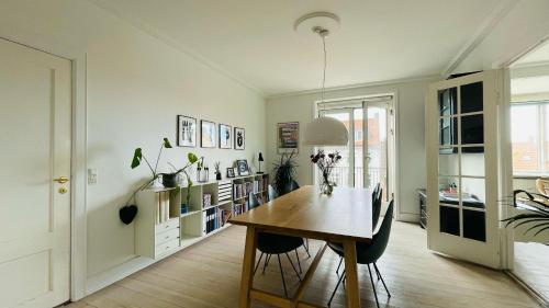 una sala da pranzo con tavolo e sedie in legno di ApartmentInCopenhagen Apartment 80 a Copenaghen