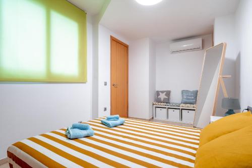 a bedroom with a bed with blue towels on it at oasis en el centro de manresa in Manresa