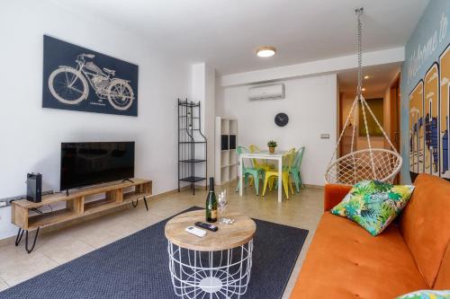 a living room with an orange couch and a tv at oasis en el centro de manresa in Manresa