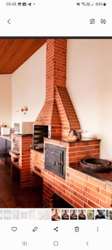 a brick fireplace with a stove in a room at Hospedagem Aconchegante in Espirito Santo Do Pinhal