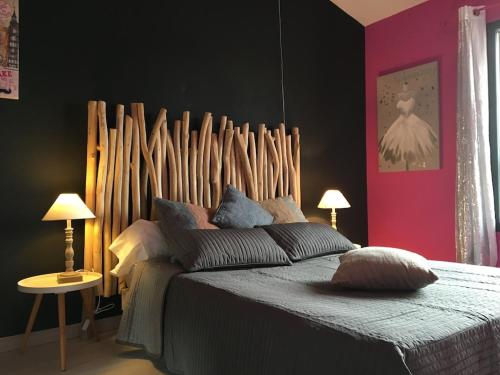 une chambre avec un grand lit avec une tête de lit en bois dans l'établissement Provençal bastide in Uzès, à Uzès
