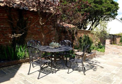 un tavolo nero e sedie su un patio di The Garden Room a Woodbridge