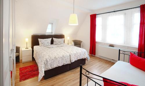ズールにあるAppartement Stadtpartieのベッドルーム1室(赤いカーテン付きの大型ベッド1台付)