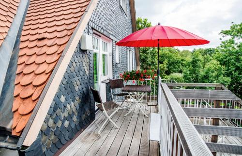 a patio with a table and a red umbrella at Appartement Stadtpartie in Suhl