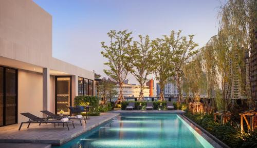 een zwembad in het midden van een gebouw bij Walton Suites Sukhumvit in Bangkok