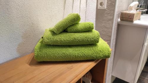 einen Stapel grüner Handtücher, die auf einer Theke sitzen in der Unterkunft Stiegenstübchen am Weinberg in Dresden