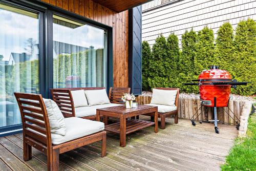 a patio with chairs and a table and a fire hydrant at Gintarinė KOPA in Palanga