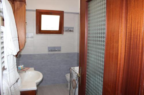 une salle de bain avec un lavabo et des toilettes et une fenêtre dans l'établissement LA CASETTA DI ASIA, à Vico Equense
