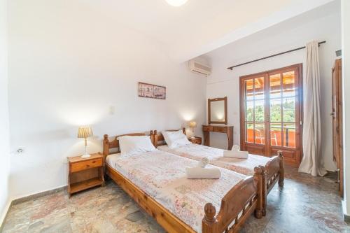 een slaapkamer met een groot bed en een raam bij Arianna Studio Ground Floor 7 in Paleokastritsa