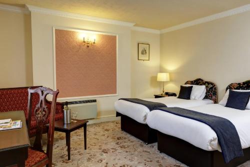 a hotel room with two beds and a chair at Royal Victoria Hotel in Hastings
