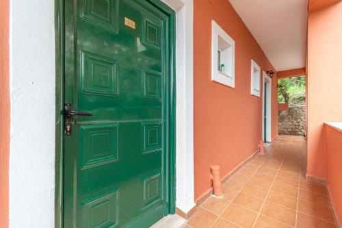 a green door in a house with a hallway at Arianna Superior Studio 18 in Paleokastritsa