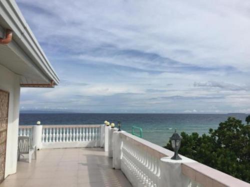 a balcony of a house with a view of the ocean at The Cronin Residences by Cocotel in Oslob