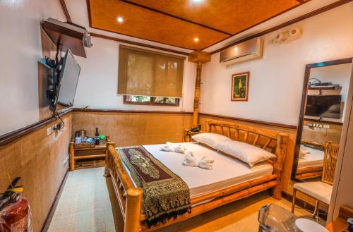 a bedroom with a bed with towels on it at Noni's Resort in Alitagtag