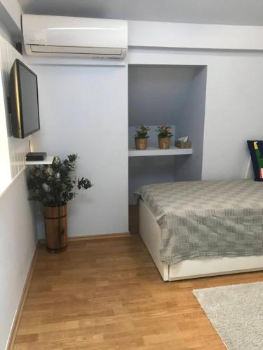 Schlafzimmer mit einem Bett und einem Flachbild-TV in der Unterkunft Tulipán Apartman Kápolnásnyék in Kápolnásnyék