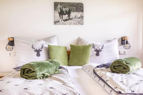 a bedroom with two beds with pillows and a deer picture at Unterwöhrlehen in Faistenau
