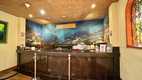 a bar in a restaurant with a painting on the wall at Coco Grove Beach Resort, Siquijor Island in Siquijor