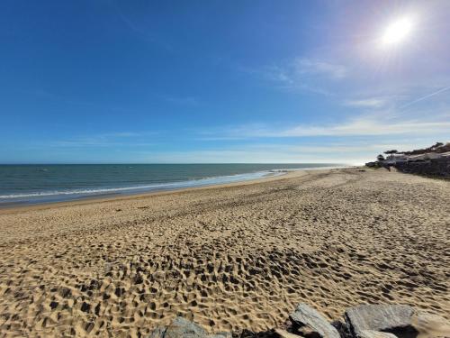 ein Sandstrand mit dem Meer im Hintergrund in der Unterkunft Maison Princesse in La Tranche-sur-Mer