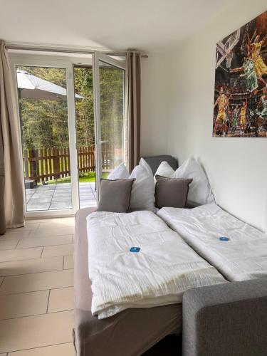a bed in a room with a sliding glass door at Ferienwohnung Traunkirchen mit Seeblick in Traunkirchen
