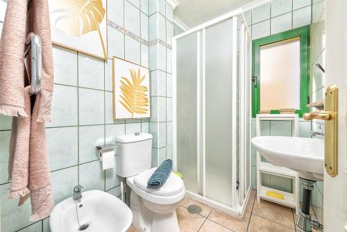 a bathroom with a toilet and a sink at Apartamento Tropical en playa del inglés in Maspalomas