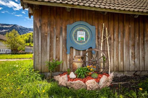 a wooden shed with a flower bed in front of it at Unterwöhrlehen in Faistenau