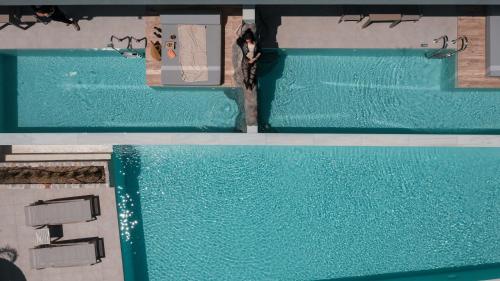 una vista sull'alto di due piscine con persone di Sun City Luxury Apartments ad Asgourou