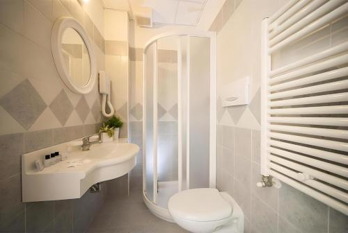 a white bathroom with a sink and a toilet at Hotel Jana in Rimini