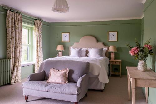 a bedroom with a large bed and a chair at Hazelhurst in Sway