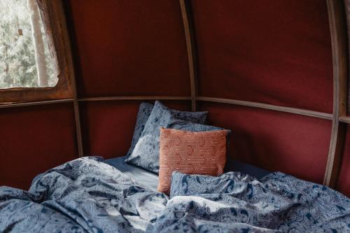 Būtingė的住宿－Nature calls - tree tents，客房内的一张带枕头和毯子的床