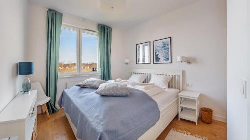 a white bedroom with a bed and a window at Nexo, Sun & Snow in Puck