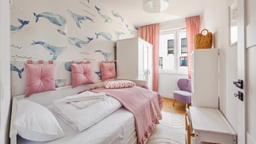 a bedroom with a bed with pink and blue dolphins on the wall at Nexo, Sun & Snow in Puck